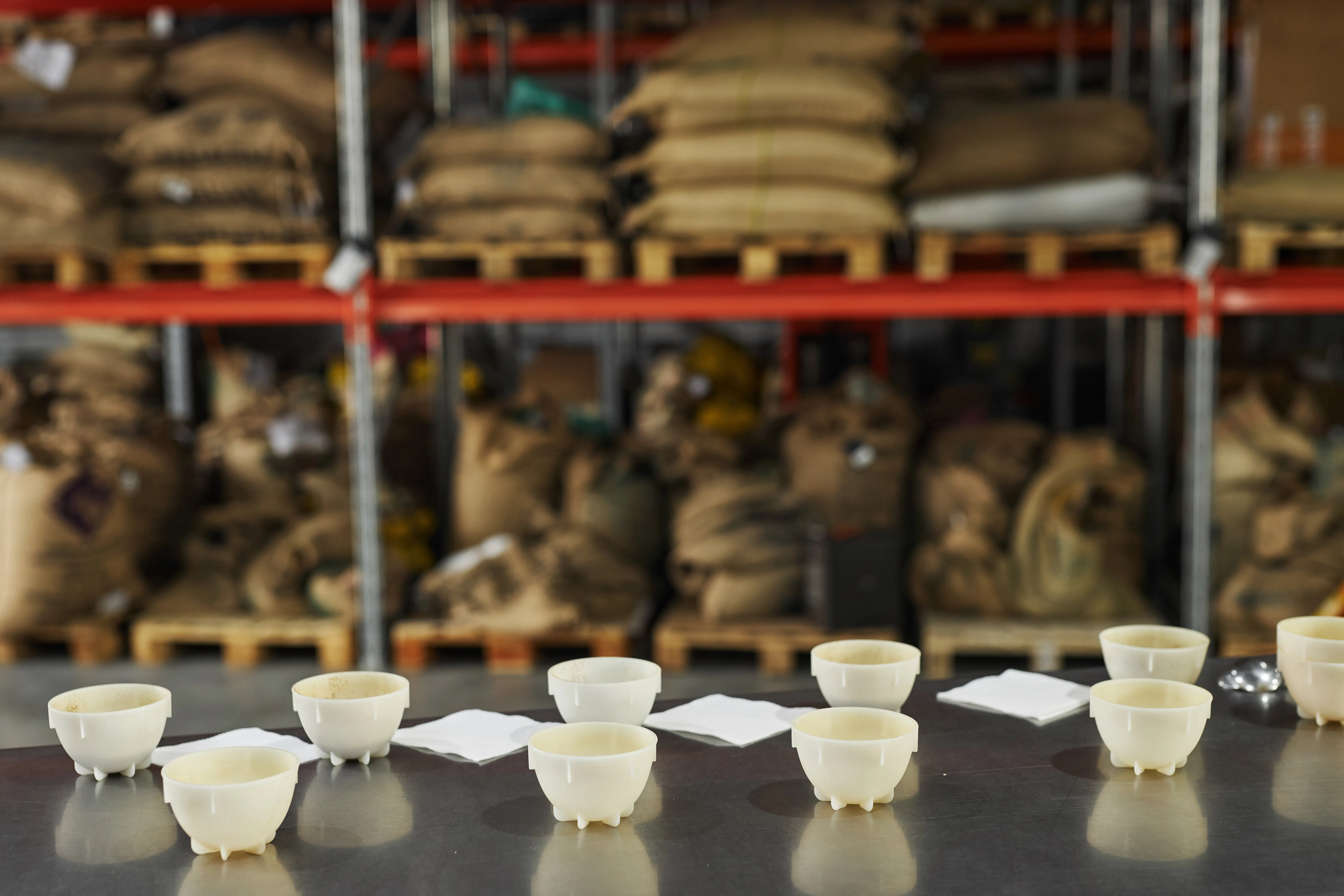 A cupping table set with tasting bowls and spoons